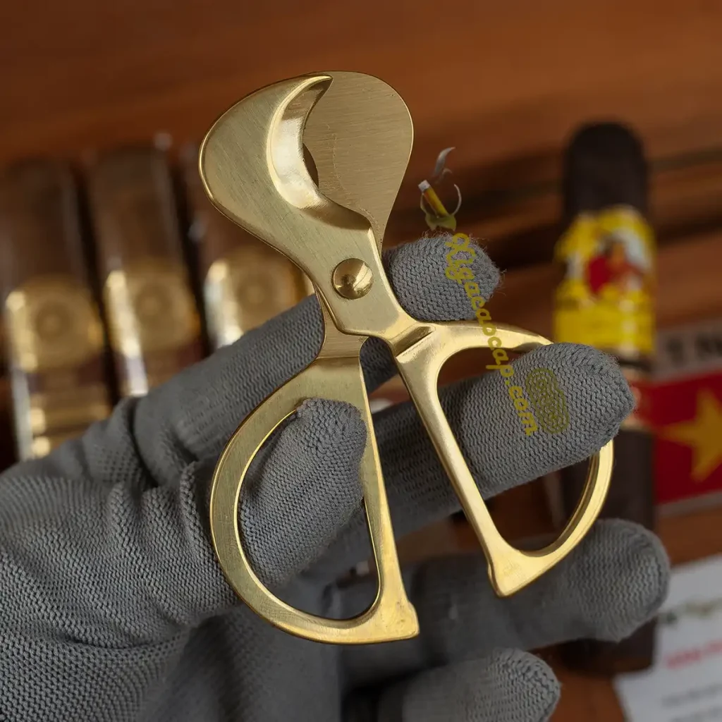 Chi tiết hai lưỡi cắt khuyết bán nguyệt đối xứng mạ vàng của kéo cắt cigar.