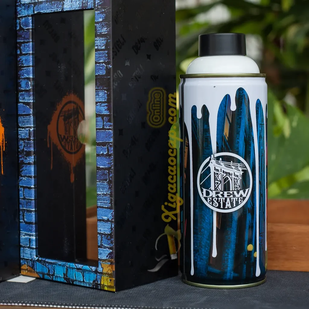 Bật lửa xì gà độc lạ Graffiti Drew Estate Lighter đặt cạnh hộp bao bì giả tường gạch