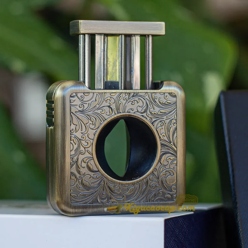 Toàn cảnh góc nghiêng nghệ thuật của chiếc dao cắt cigar Semkont bốn trong một thể hiện độ dày lớp mạ đồng giả cổ sang trọng cùng sự kết hợp hài hòa giữa các bộ phận đục lỗ gập gọn và rãnh gác điếu tiện dụng trên nền gỗ sồi tự nhiên cao cấp.