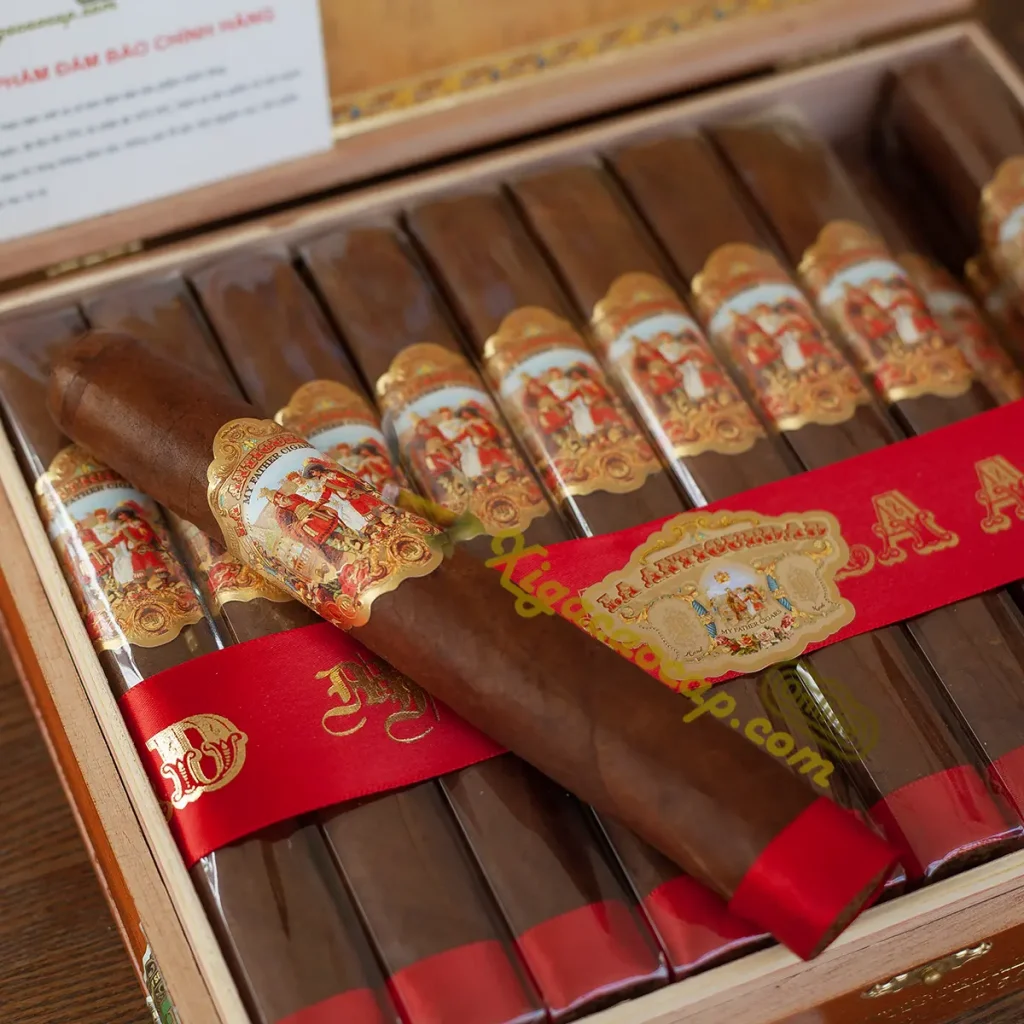 Một điếu xì gà Super Toro nằm nổi bật giữa khay chứa gỗ tuyết tùng của hộp My Father La Antiguedad mở nắp.